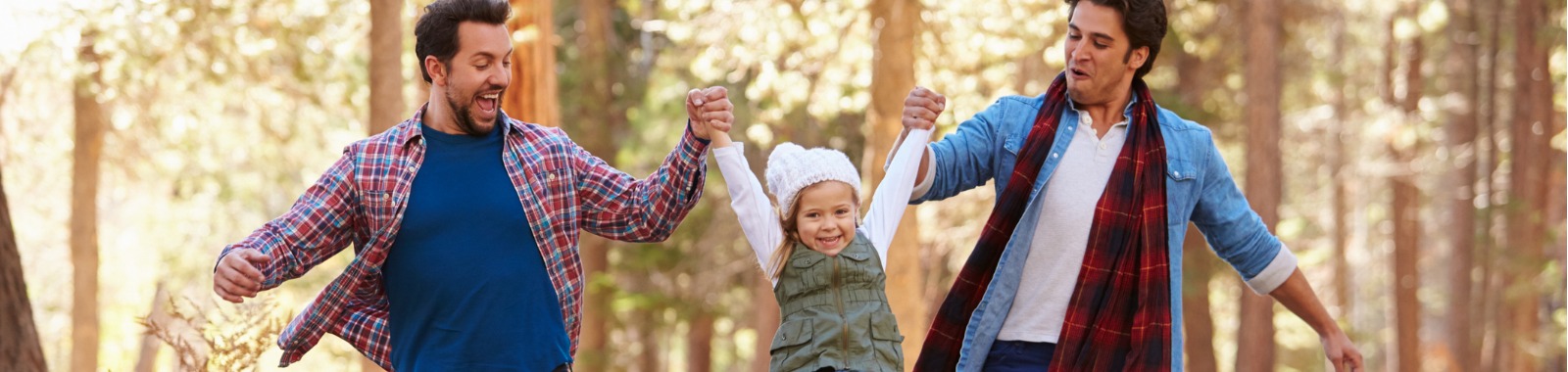 Male couple walking with daughter outdoors